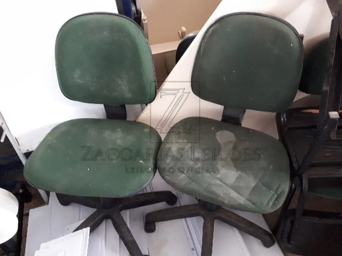LOTE 006 - MÓVEIS E UTENCILIOS  - 13 cadeiras brancas de plástico; 2 cadeiras com rodizio sem braço; 1 cadeira com rodizio com braço; 19 cadeiras fixas sem braço; 1 cadeira fixa com braço; Uma estação de trabalho, marrom sem gavetas, bem danificada; Uma pia de pestal, marca Deca, branca, quebrada; Treze lixeiras, San remo 20 litros; 12 Lixeiras Marfinite Brancas; 01 longarina de 3 lugares, banco recepção; 02 armários de duas portas, bege, com chaves; 05 balcões de duas portas; 01 Balcão de Recepção; 02 Gaveteiros de 4 gavetas com rodizio; Um tampo de mesa; 2 Bancos Veiculares de Ônibus; Um sofá de dois lugares; Um sofá de três lugares; Duas mesas redondas; dois Conjuntos mesa de refeitório de 4 e 6 lugares; 4 mesas de trabalho em Inox; 3 mesas brancas de 4 lugares; 2 Rack de servidor; 24 rolos de formulário para impressora Um carrinho para bandejas, com cinquenta bandejas; divisórias de pvc e trilhos.